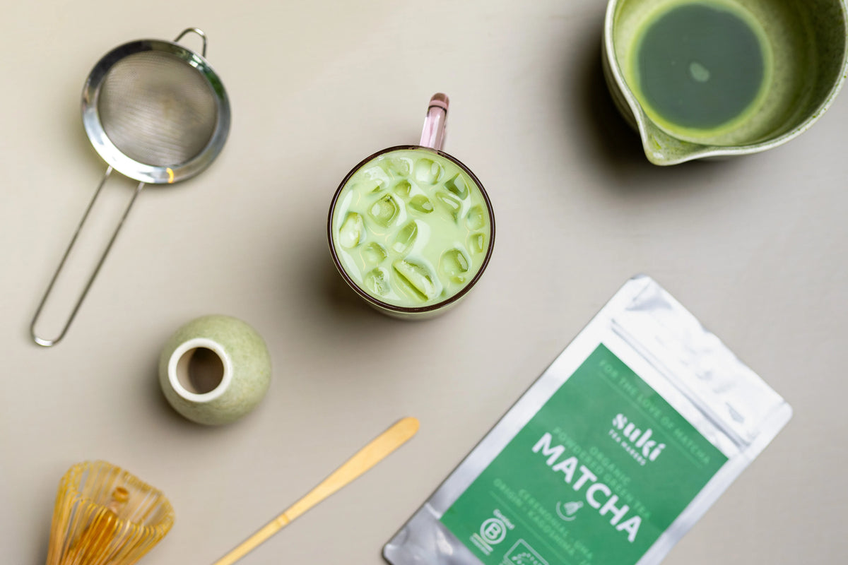 A matcha bowl, bamboo whisk and scoop laid out on a work surface